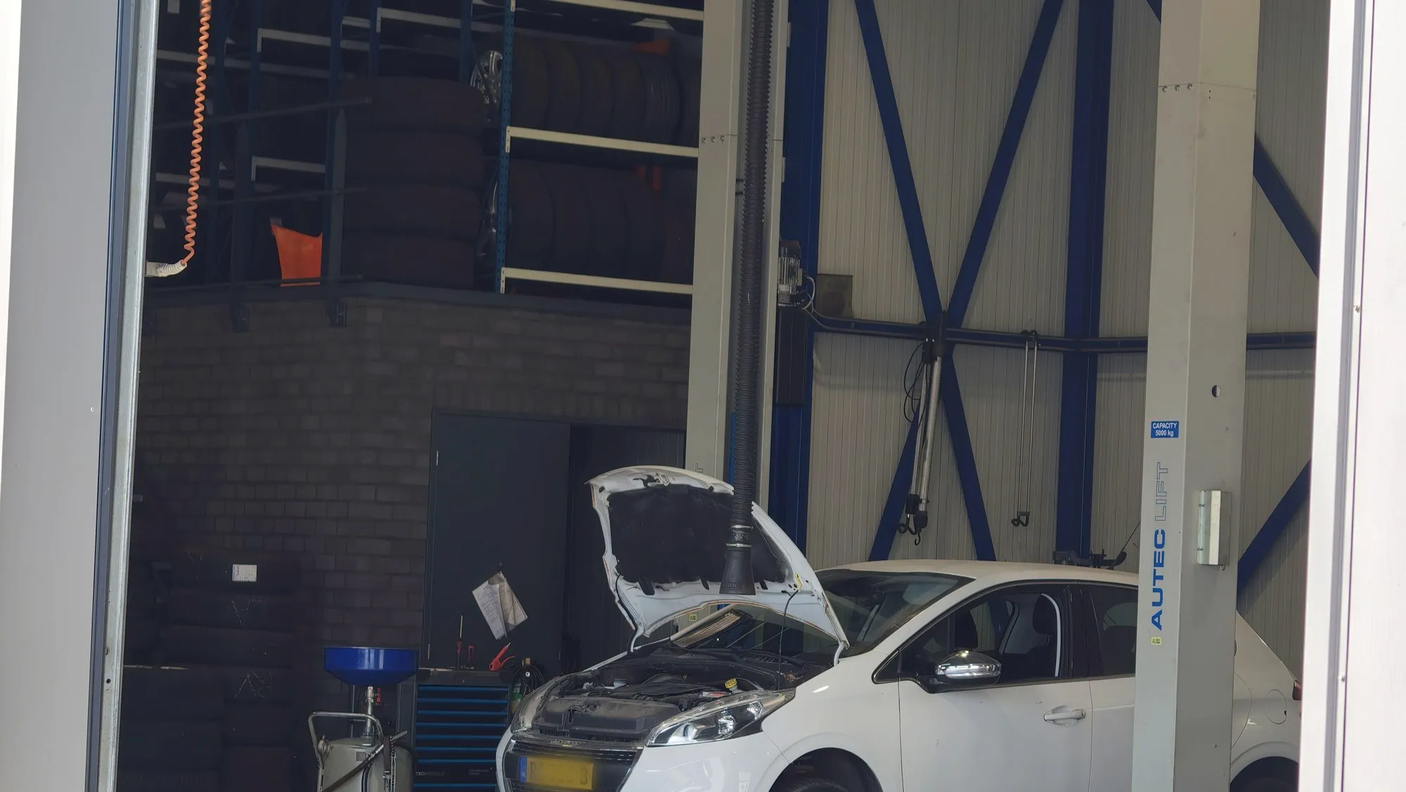 De werkplaats van Car Service Urk met twee hefbruggen en bandenopslag.